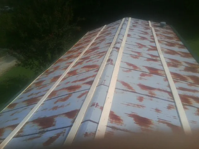 Rusted metal roof panels with new wood purlins before replacement — Storm Damage Roof Repair in Woodbourne by Roofing Brothers