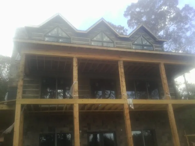 Dormers and porch framing on a large log home under construction — Roof Coating work by our crew in Woodbourne